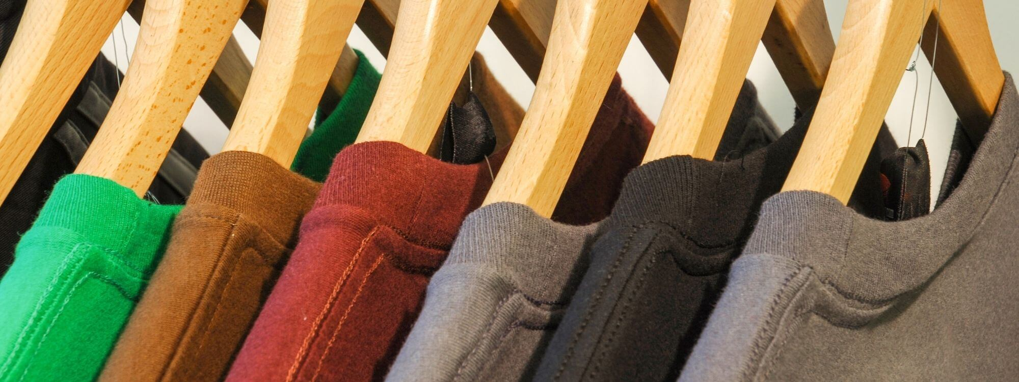a row of colorful t-shirts on hangers