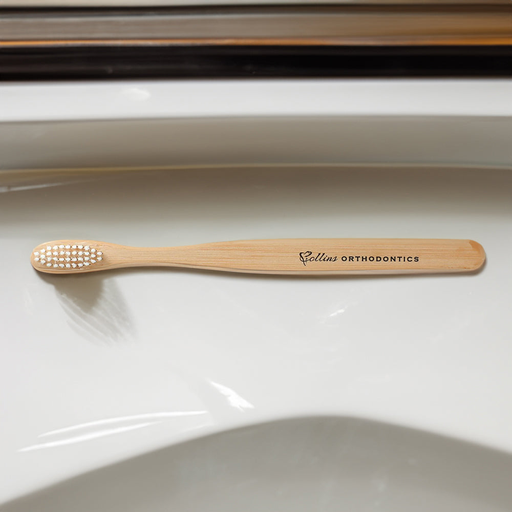 Customizable bamboo toothbrush on bathroom counter.